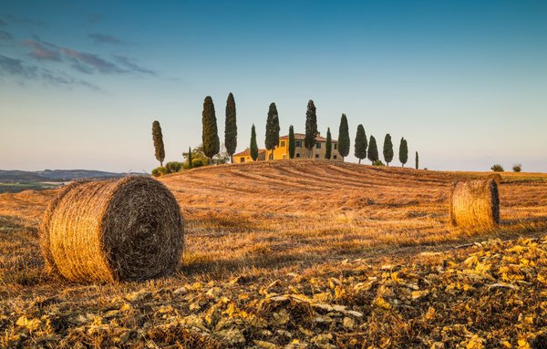 Beautiful-Tuscany-landscape-with-traditional-farm-house-and-hay-bales-in-golden-evening-light-Val-dOrcia-Italy.jpg